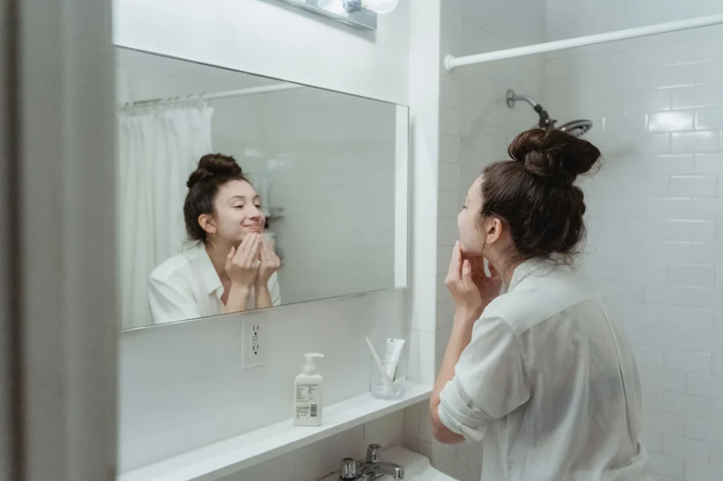 Woman following an acne skincare guide with a gentle cleansing and moisturizing routine for acne-prone skin