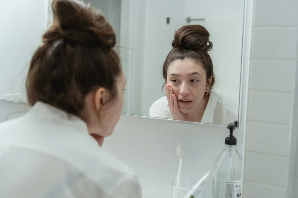 Woman following an acne skincare guide with a gentle cleansing and moisturizing routine for acne-prone skin