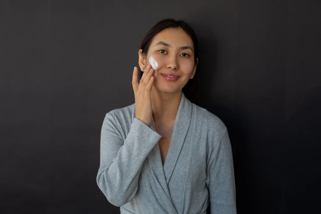 Person applying moisturizer as part of a dry skin care guide to improve hydration and support the skin barrier