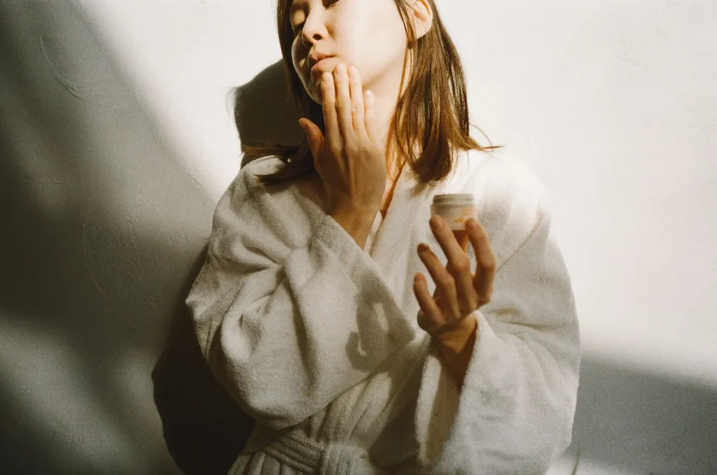 Person applying moisturizer as part of a dry skin care guide to improve hydration and support the skin barrier