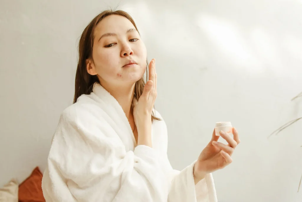 Person applying moisturizer as part of a dry skin care guide to improve hydration and support the skin barrier