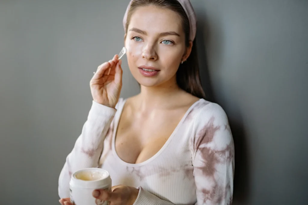 Applying facial moisturizer to maintain skin hydration and barrier health