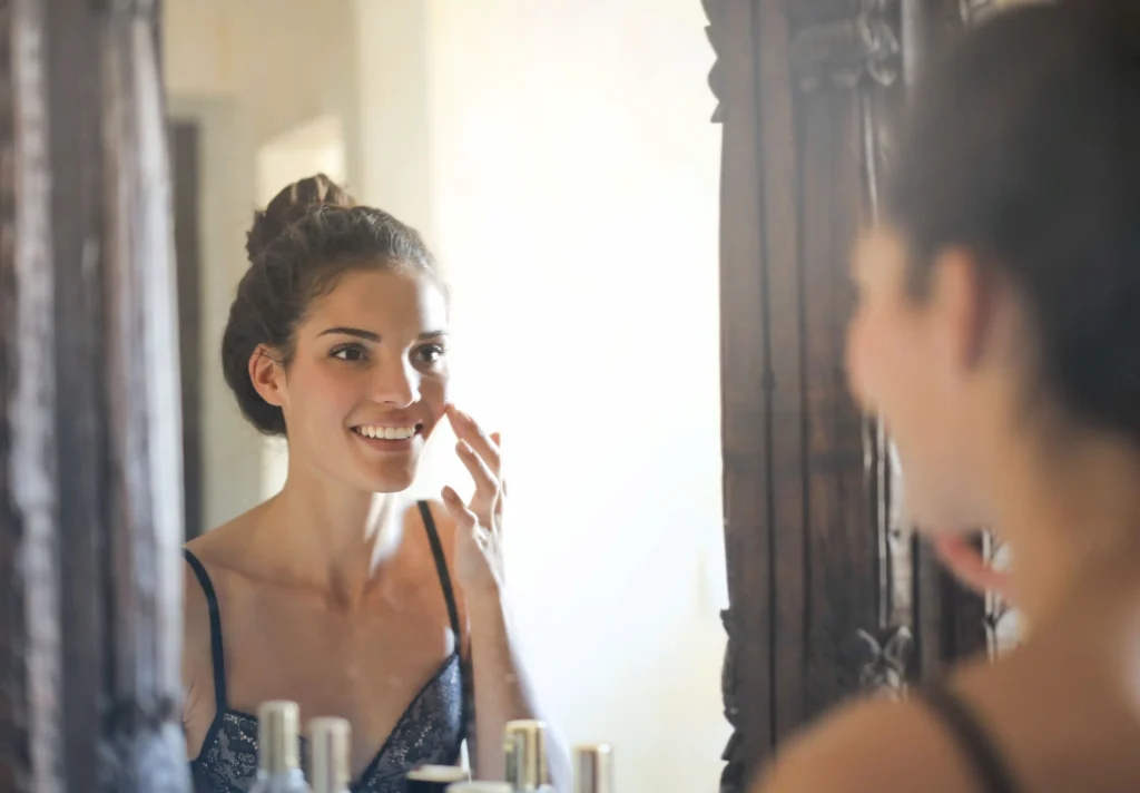 Woman examining common skin concerns including acne, redness, and dry skin