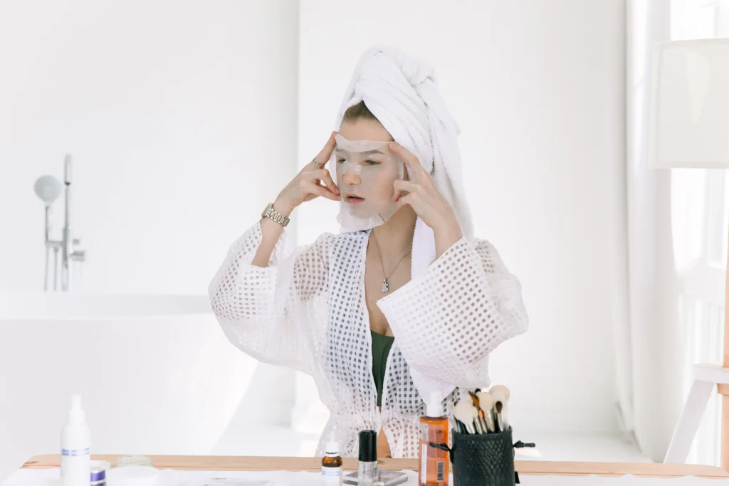 Woman following a beginner skincare routine using cleanser, moisturizer, and sunscreen.