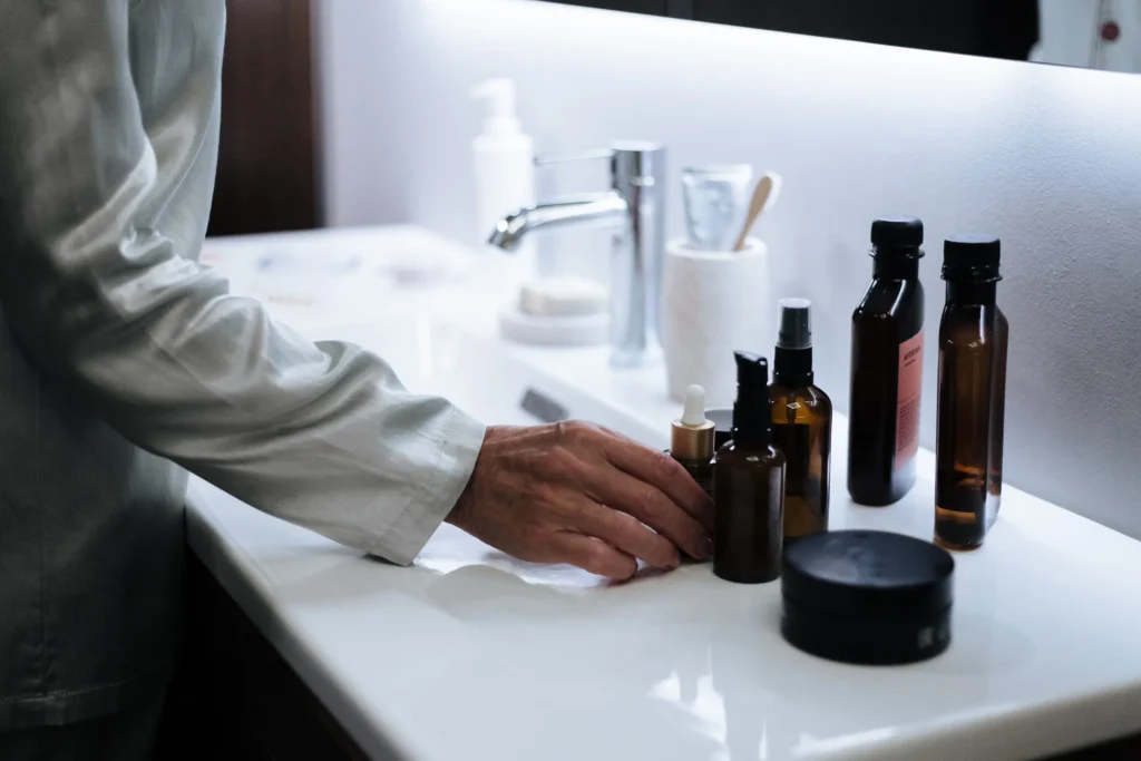 Woman following a daily skincare routine using cleanser, serum, moisturizer, and sunscreen for healthy-looking skin.
