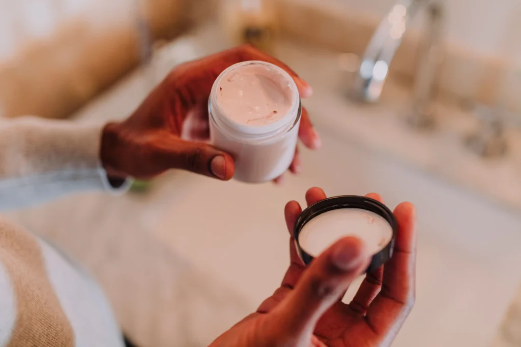 Woman following a daily skincare routine using cleanser, serum, moisturizer, and sunscreen for healthy-looking skin.