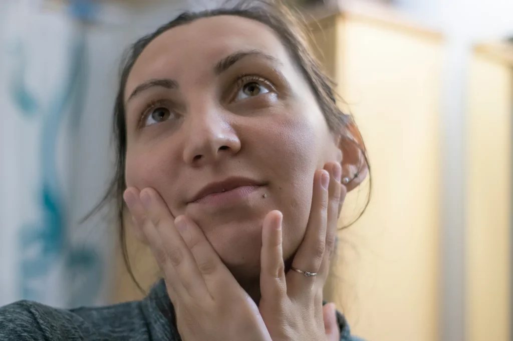 Woman exfoliating her face as part of a healthy skincare routine for every skin type